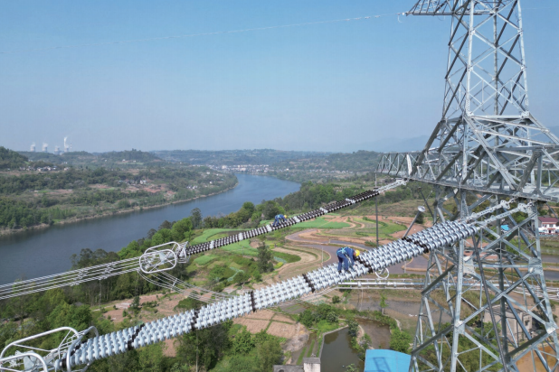 2025年4月8日,在重庆市合川区,国网重庆超高压公司输电运检员工 完成重庆段最后一段铁塔的登塔走线,标志着国家“十四五”电力发展规划重 点项目—哈密至重庆±800千伏特高压直流输电工程重庆段完成走线验 收。图为输电运检员工高空开展走线验收工作。