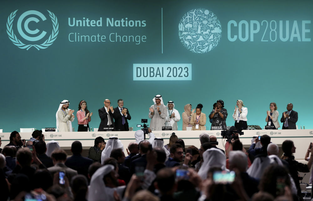 2023年12月13日，在阿聯酋迪拜舉行的《聯合國氣候變化框架公約》第二十八次締約方大會在“加時”一天后閉幕。這是大會主席蘇爾坦·賈比爾宣布達成“阿聯酋共識”后，參會人員起立鼓掌。新華社記者 王東震 攝